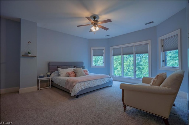 bedroom featuring ceiling fan, carpet, and multiple windows