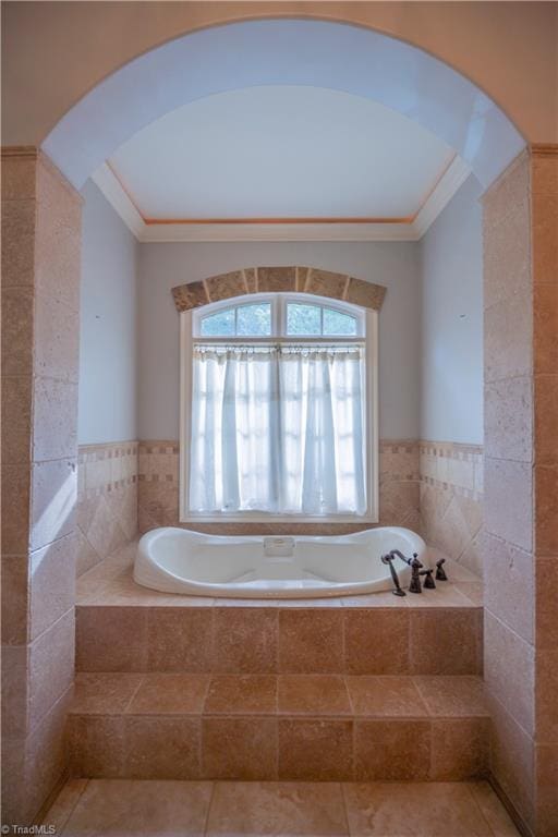 bathroom featuring ornamental molding, tile patterned floors, tile walls, and tiled bath