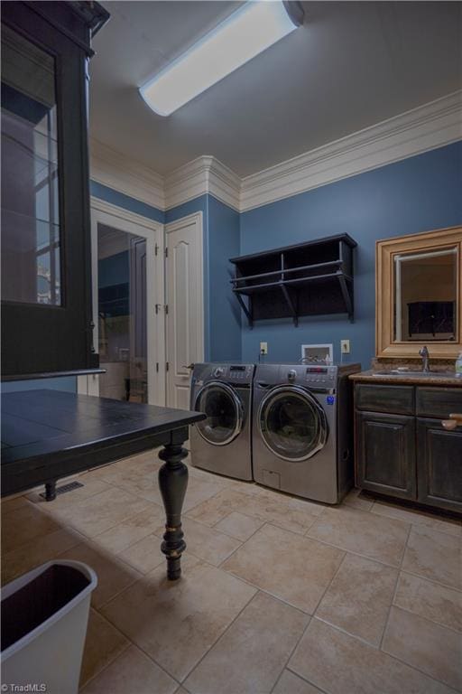 washroom featuring cabinets, separate washer and dryer, sink, and ornamental molding