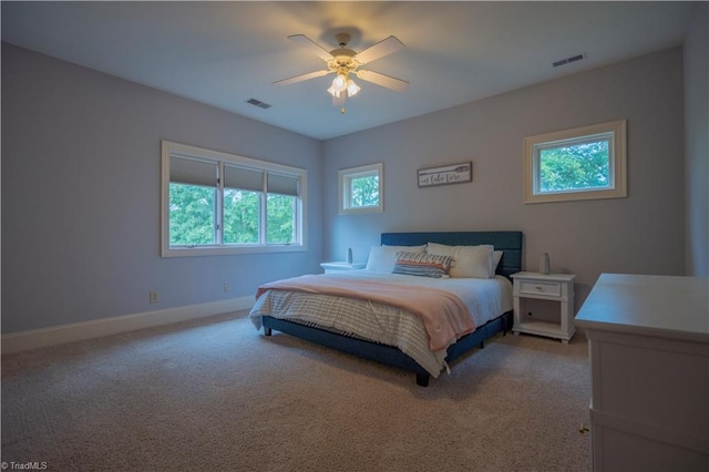 carpeted bedroom featuring ceiling fan and multiple windows