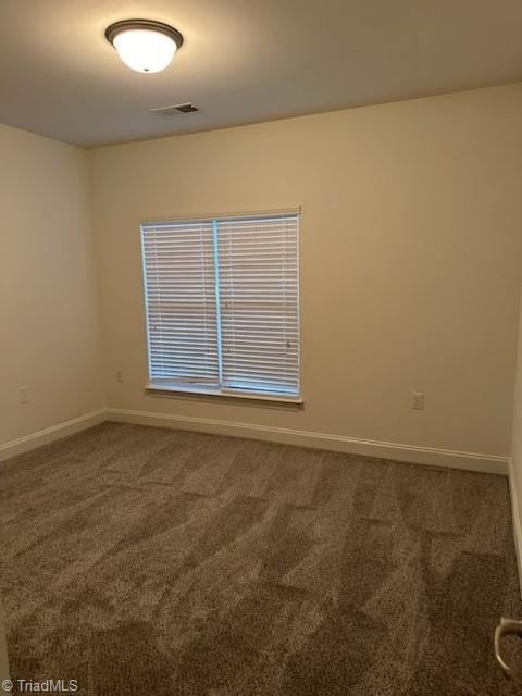 carpeted empty room with visible vents and baseboards