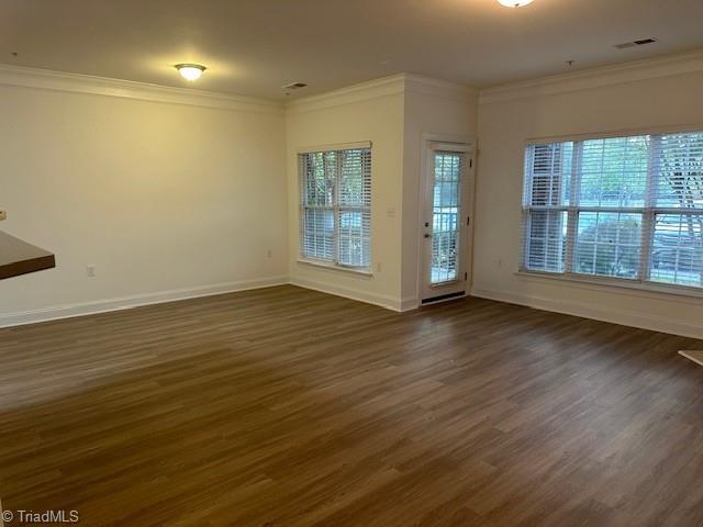 empty room featuring crown molding and dark hardwood / wood-style floors