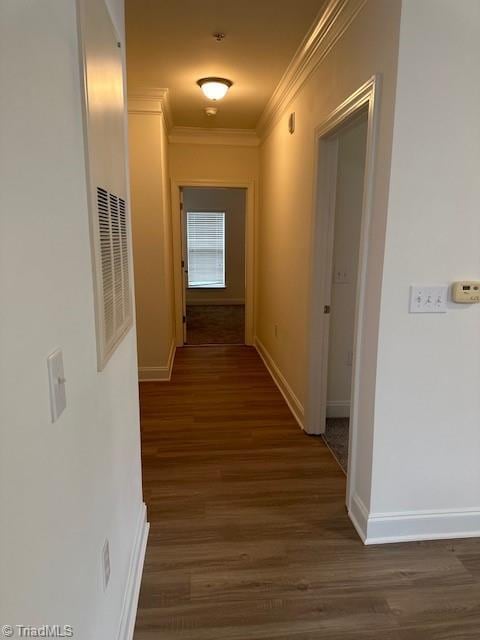 hall with ornamental molding, baseboards, and wood finished floors