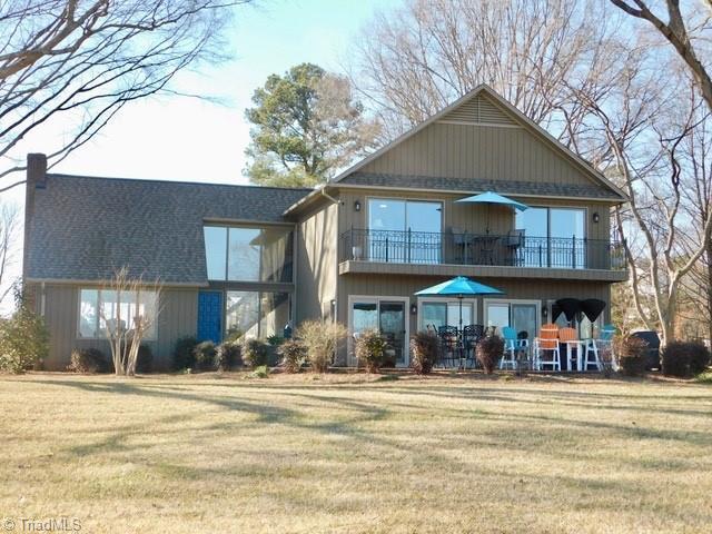 back of house featuring a yard and a balcony