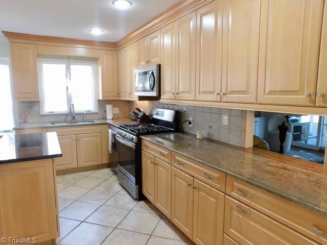 kitchen featuring light tile patterned flooring, sink, stainless steel appliances, light stone countertops, and decorative backsplash