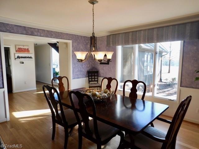 dining area with crown molding and hardwood / wood-style floors