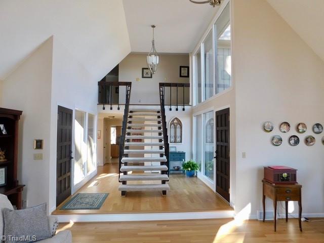 entryway with a healthy amount of sunlight, hardwood / wood-style floors, high vaulted ceiling, and french doors