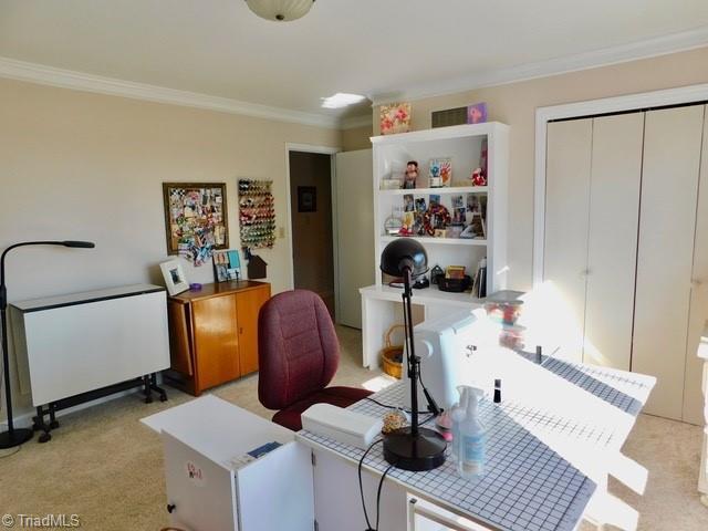 office area featuring ornamental molding and light carpet