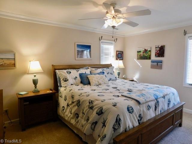 bedroom featuring crown molding, carpet floors, and ceiling fan