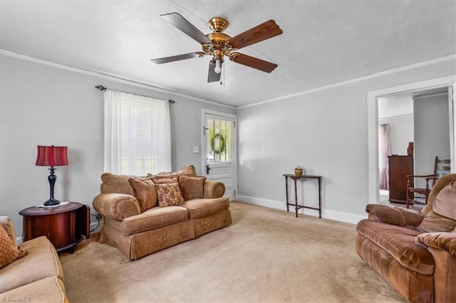 living room featuring baseboards, ornamental molding, ceiling fan, and light colored carpet