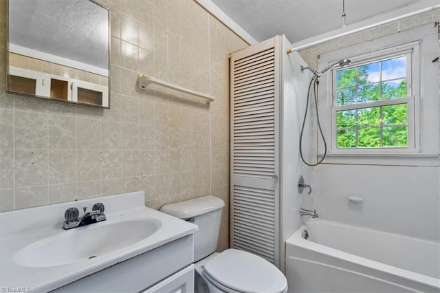 bathroom featuring toilet, shower / bath combination, tile walls, and vanity