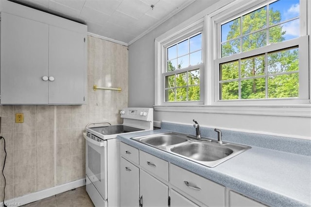 kitchen with ornamental molding, light countertops, white cabinetry, white range with electric stovetop, and a sink