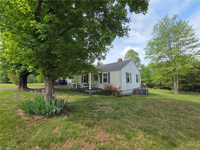 view of front of house featuring a front lawn, central AC, and a chimney