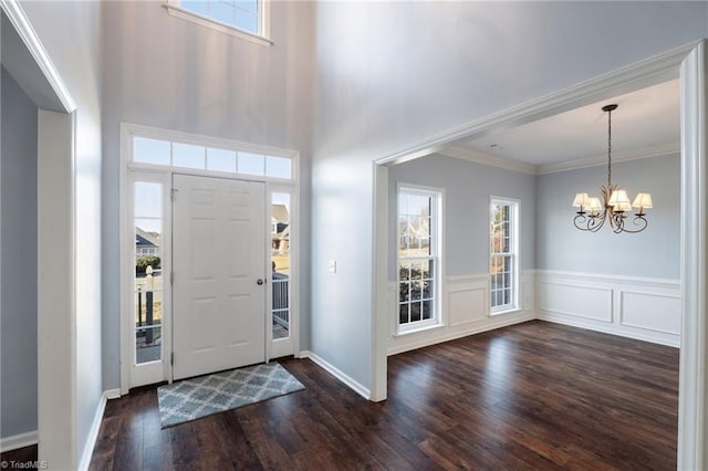 foyer featuring ornamental molding, an inviting chandelier, and dark hardwood / wood-style flooring