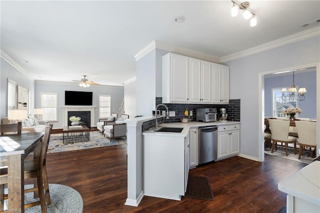 kitchen with decorative light fixtures, white cabinetry, sink, dark hardwood / wood-style flooring, and stainless steel dishwasher