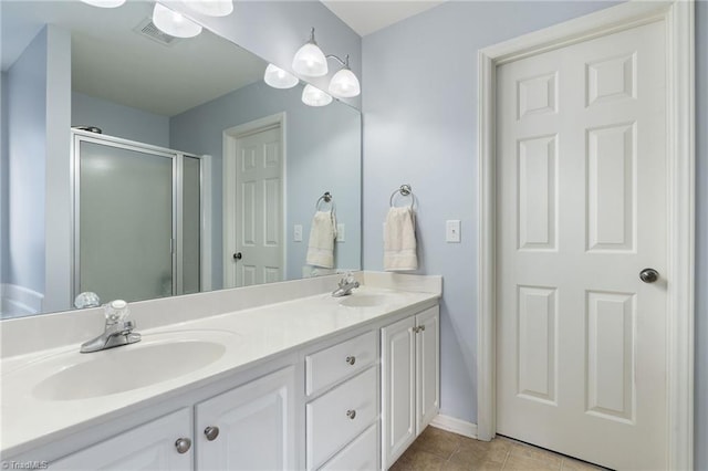 bathroom featuring walk in shower, vanity, and tile patterned flooring