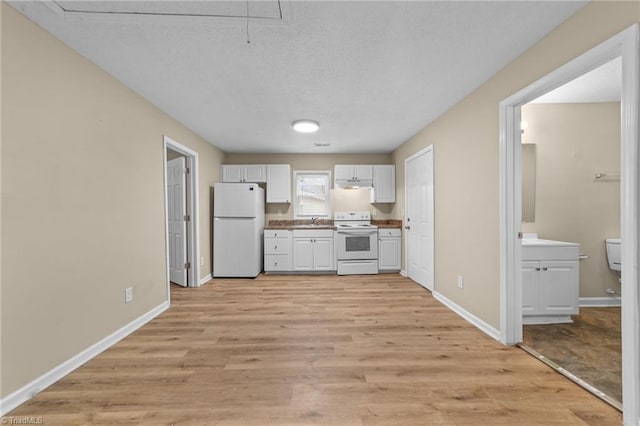 kitchen with white appliances, sink, light hardwood / wood-style flooring, and a textured ceiling