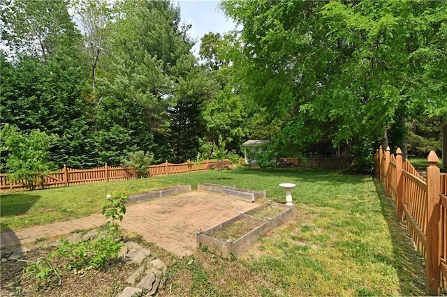 view of yard with a fenced backyard and a garden