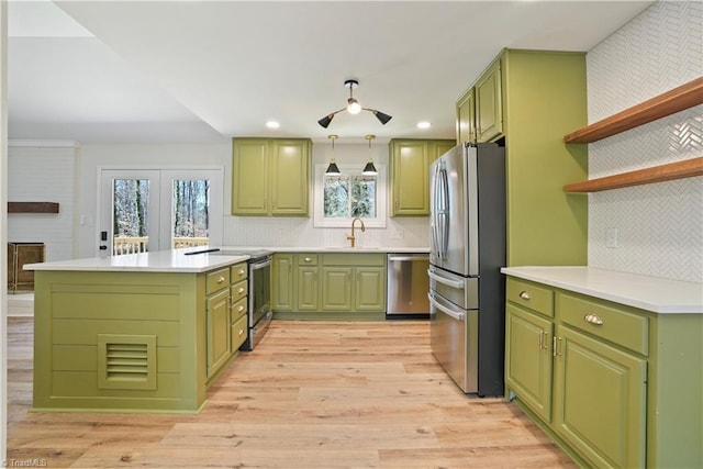 kitchen featuring light wood-style flooring, appliances with stainless steel finishes, open shelves, and green cabinetry