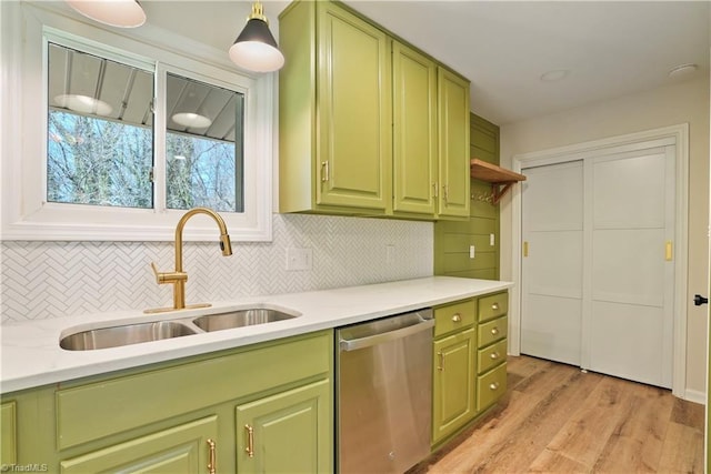 kitchen with dishwasher, tasteful backsplash, green cabinets, and a sink