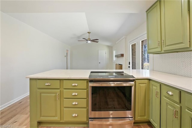 kitchen with green cabinets, lofted ceiling, decorative backsplash, stainless steel electric range, and a peninsula