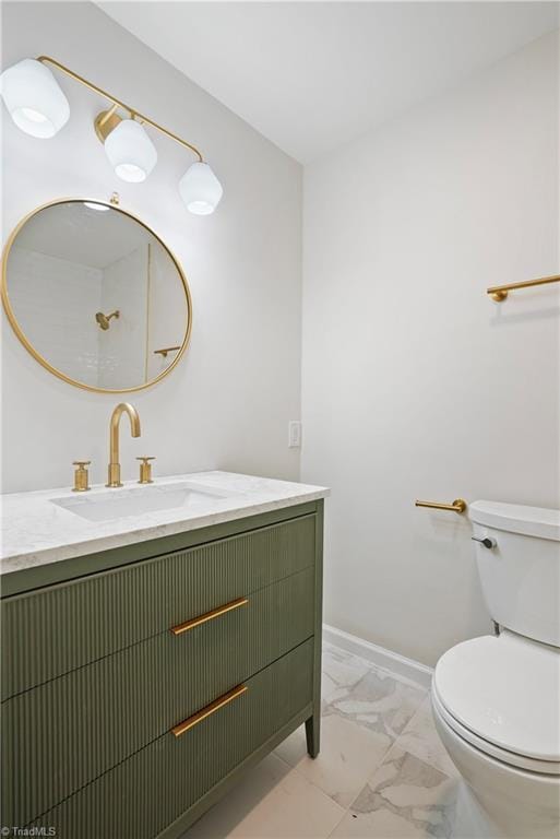 half bathroom featuring baseboards, toilet, marble finish floor, and vanity