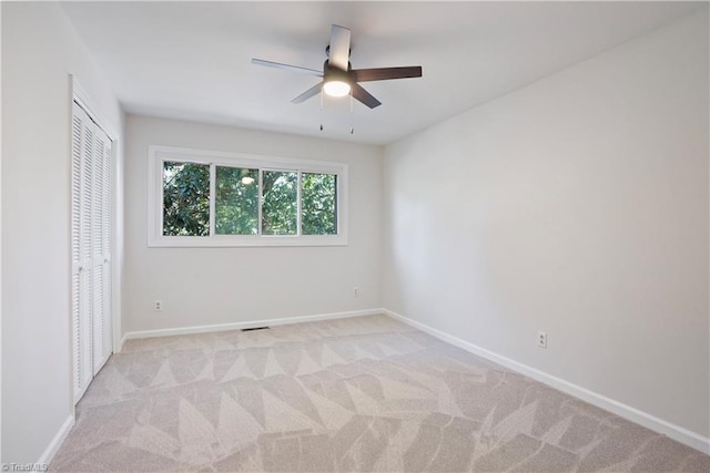 unfurnished bedroom with visible vents, light carpet, a ceiling fan, a closet, and baseboards