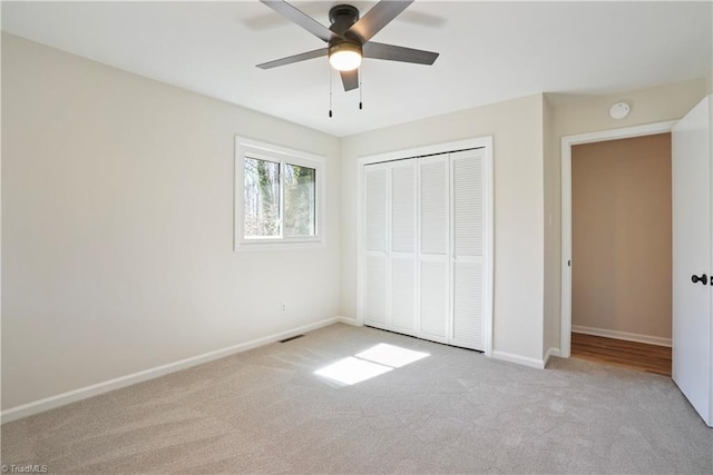 unfurnished bedroom with a closet, ceiling fan, baseboards, and carpet