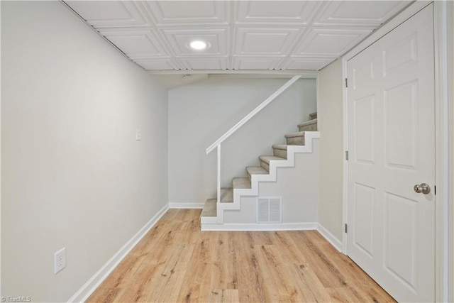 stairway featuring visible vents, baseboards, and wood finished floors