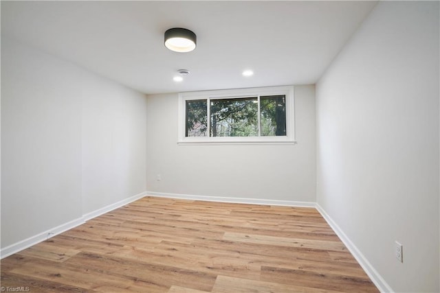 spare room featuring baseboards and wood finished floors