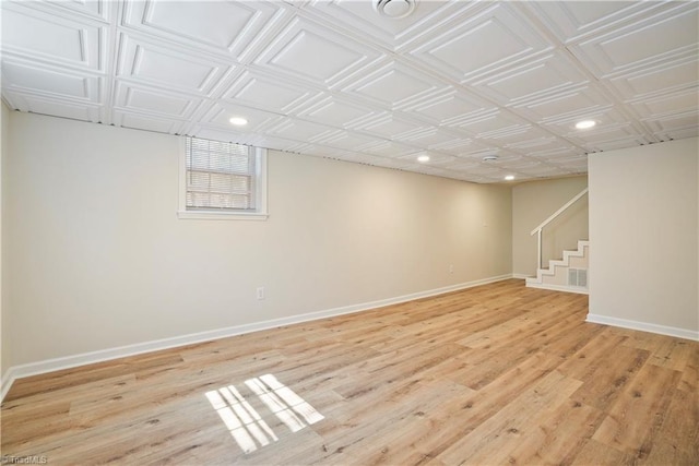 below grade area featuring stairway, recessed lighting, baseboards, and light wood-type flooring