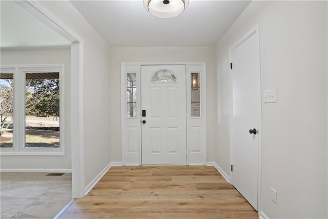 foyer featuring visible vents, baseboards, and light wood finished floors