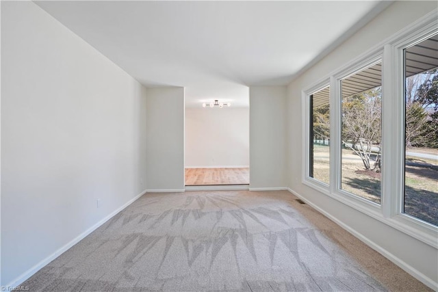 empty room featuring baseboards and carpet flooring