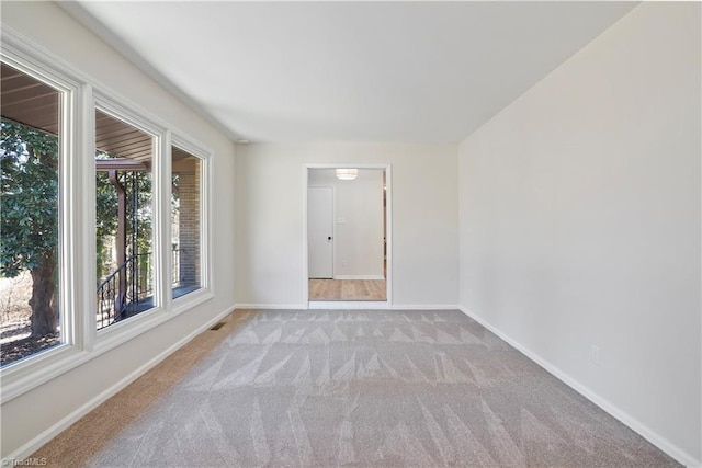 spare room featuring visible vents, baseboards, and carpet