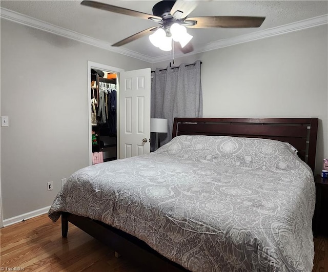 6905 Harlow Dr, Archdale, NC 27263 - bedroom with wood finished floors, ornamental molding, baseboards, a ceiling fan, and a walk in closet