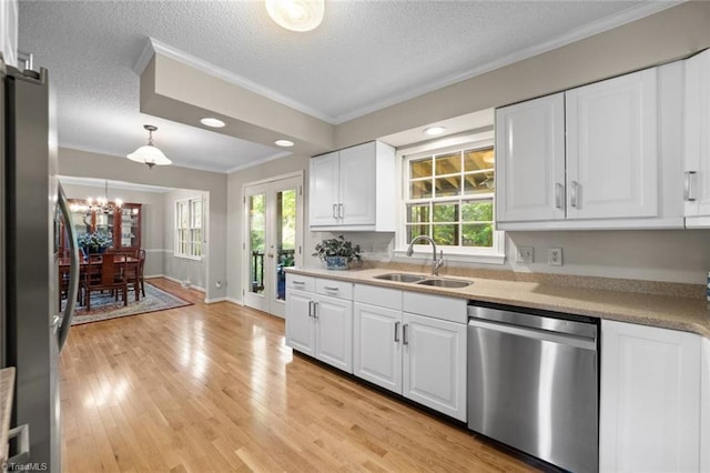 kitchen featuring white cabinets, appliances with stainless steel finishes, a sink, a textured ceiling, and ornamental molding