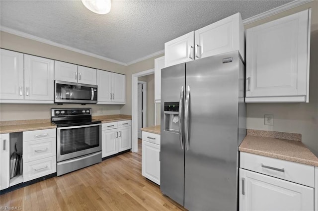 kitchen with appliances with stainless steel finishes, light wood-type flooring, and white cabinetry