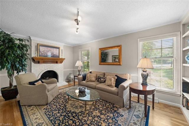 living area featuring crown molding, a brick fireplace, baseboards, a textured ceiling, and light wood finished floors