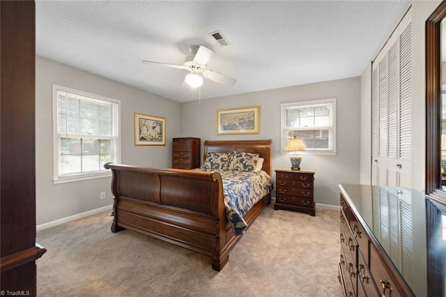 bedroom with baseboards, light colored carpet, and multiple windows
