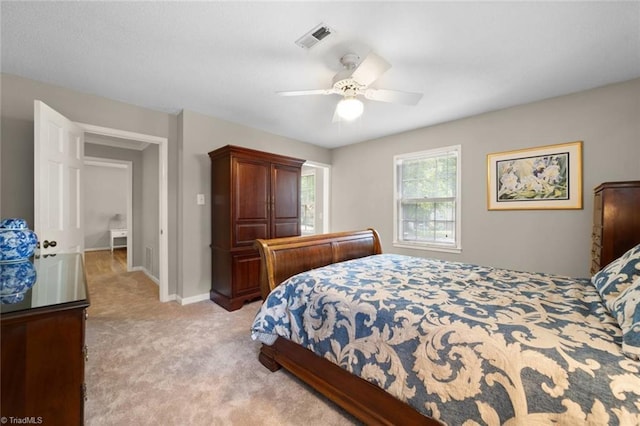 carpeted bedroom with visible vents, baseboards, and ceiling fan