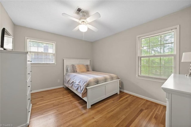 bedroom with baseboards, a ceiling fan, and light wood finished floors