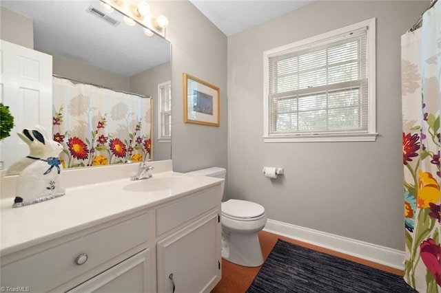 bathroom featuring visible vents, baseboards, toilet, and vanity