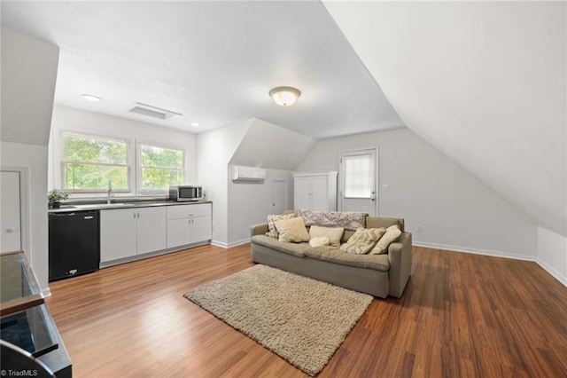 living area featuring a wall mounted AC, light wood-style flooring, and a wealth of natural light