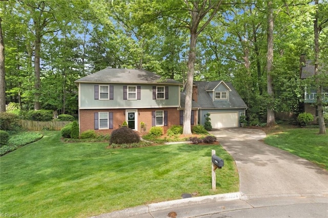 view of front of home featuring fence, driveway, a front lawn, and brick siding