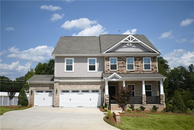 craftsman inspired home with a porch, a garage, and a front yard