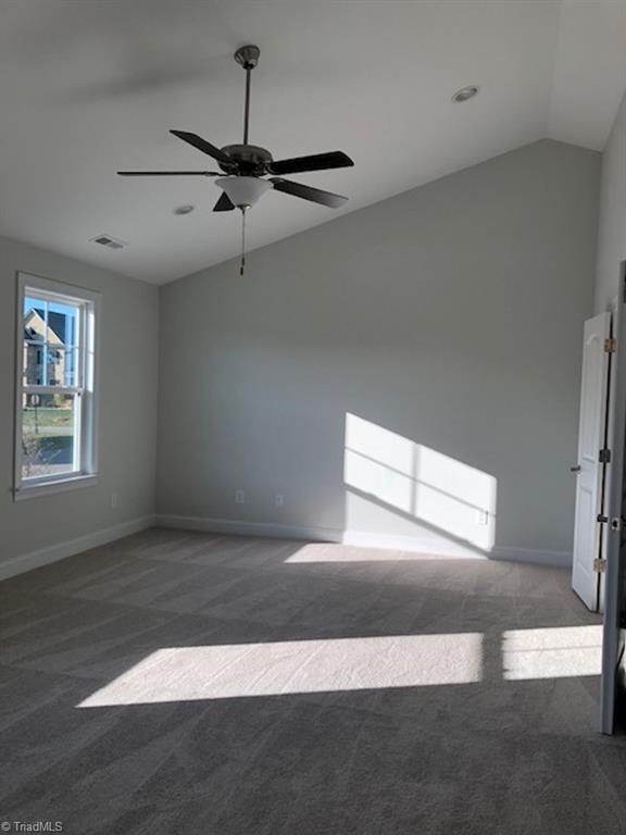 carpeted empty room featuring lofted ceiling and ceiling fan