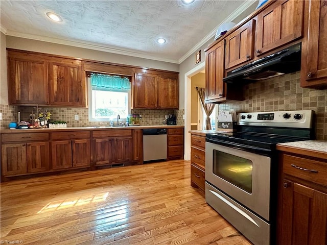 kitchen featuring decorative backsplash, appliances with stainless steel finishes, light hardwood / wood-style flooring, crown molding, and sink