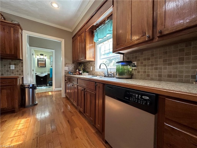 kitchen with backsplash, crown molding, sink, light wood-type flooring, and stainless steel dishwasher