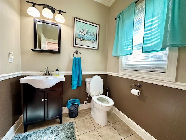 bathroom with toilet, vanity, tile patterned floors, and a wealth of natural light