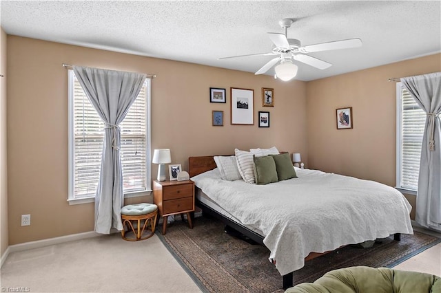 carpeted bedroom with baseboards, a textured ceiling, and ceiling fan